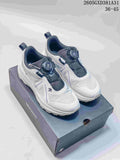 Pair of white and gray Descente sneakers with dial closures, shown on a Descente shoe box