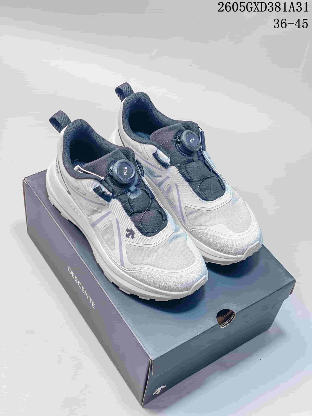 Pair of white and gray Descente sneakers with dial closures, shown on a Descente shoe box