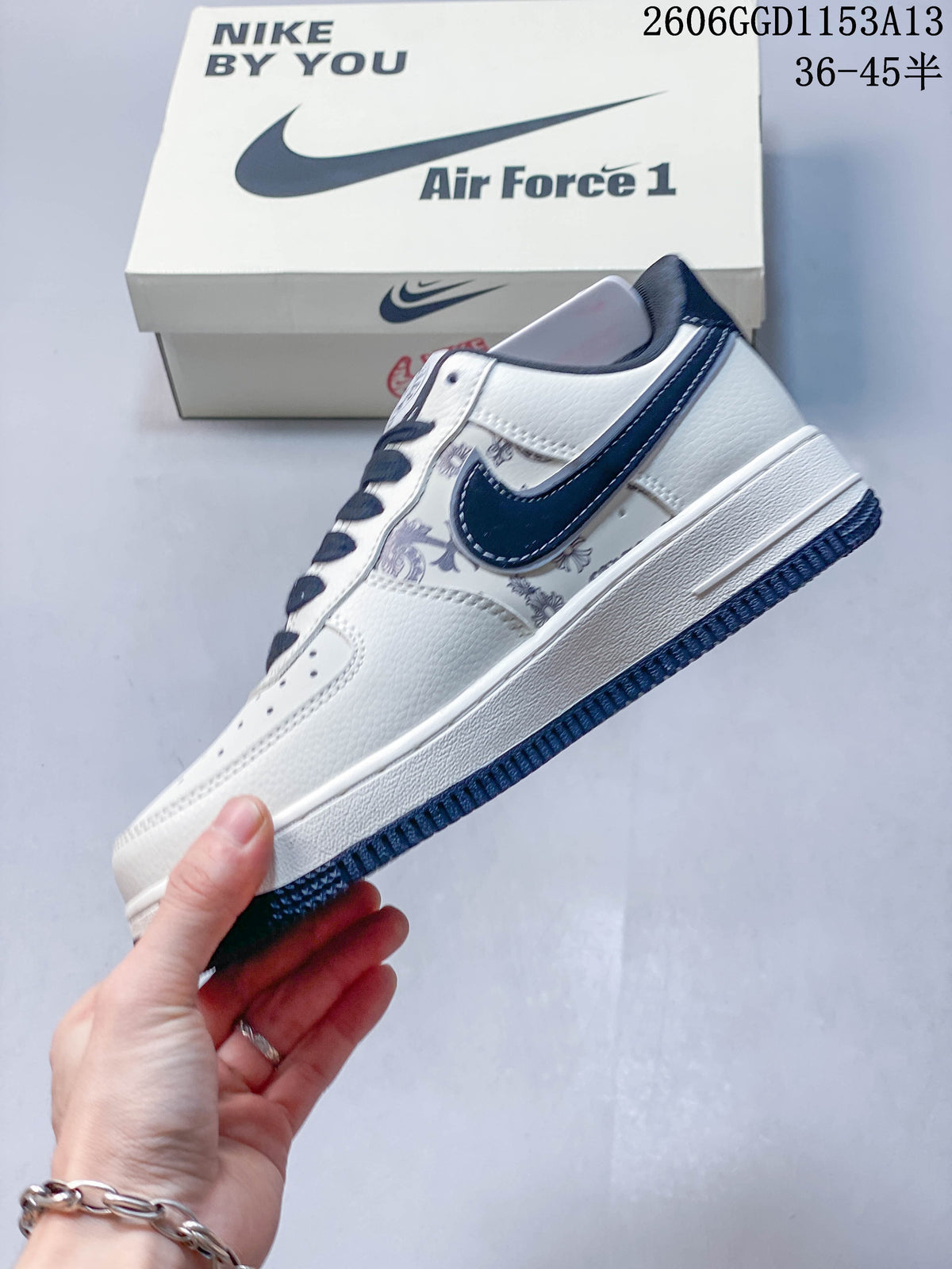 Side profile showing the navy Swoosh, printed panels, cream upper, and navy outsole