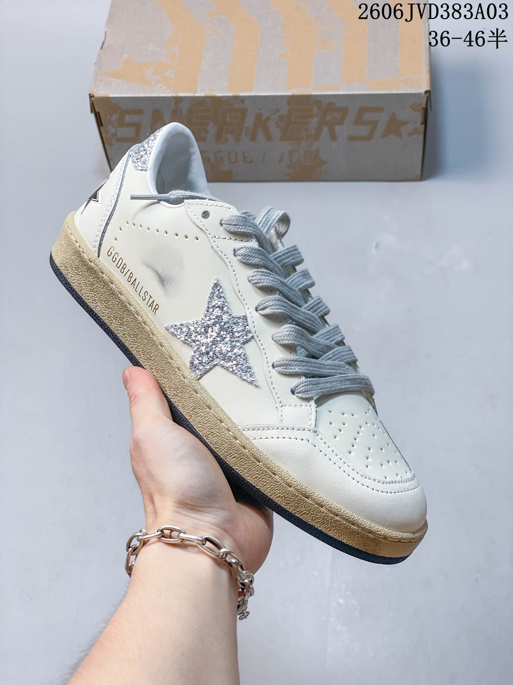 Angled side view of a Golden Goose Super-Star sneaker with glitter star, gray laces, and distressed-look sole