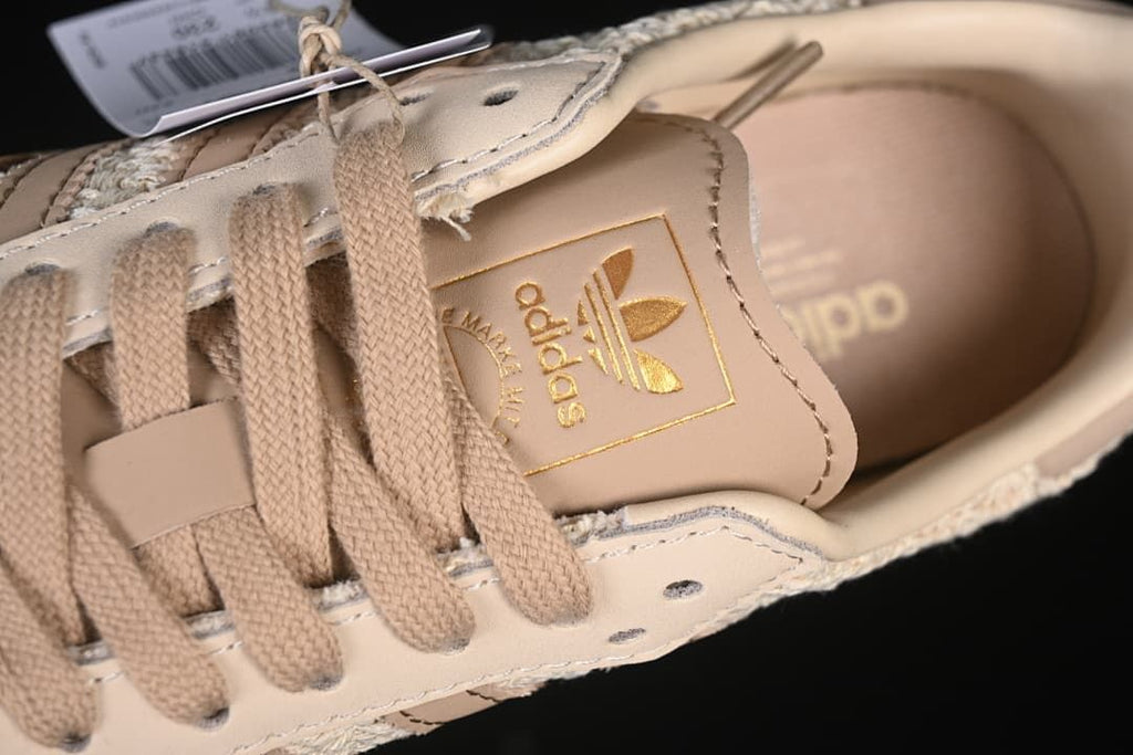 Close-up of the adidas tongue label, beige laces and upper