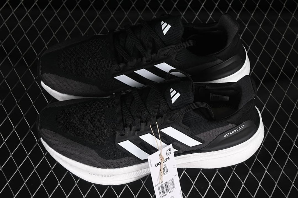 Pair of black and grey Adidas Ultraboost 5 shoes with white stripes