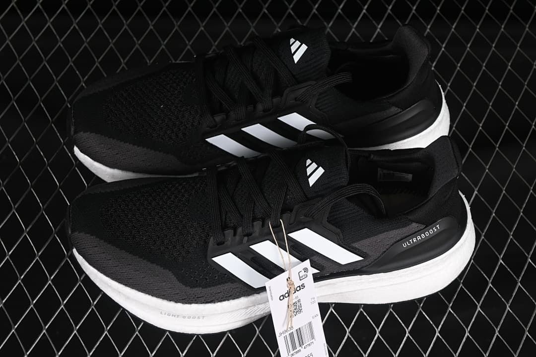 Pair of black and grey Adidas Ultraboost 5 shoes with white stripes