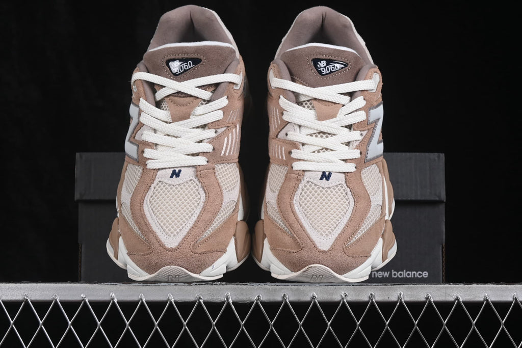 Front view of the paired beige New Balance 9060 sneakers with white laces and 9060 tongue labels.