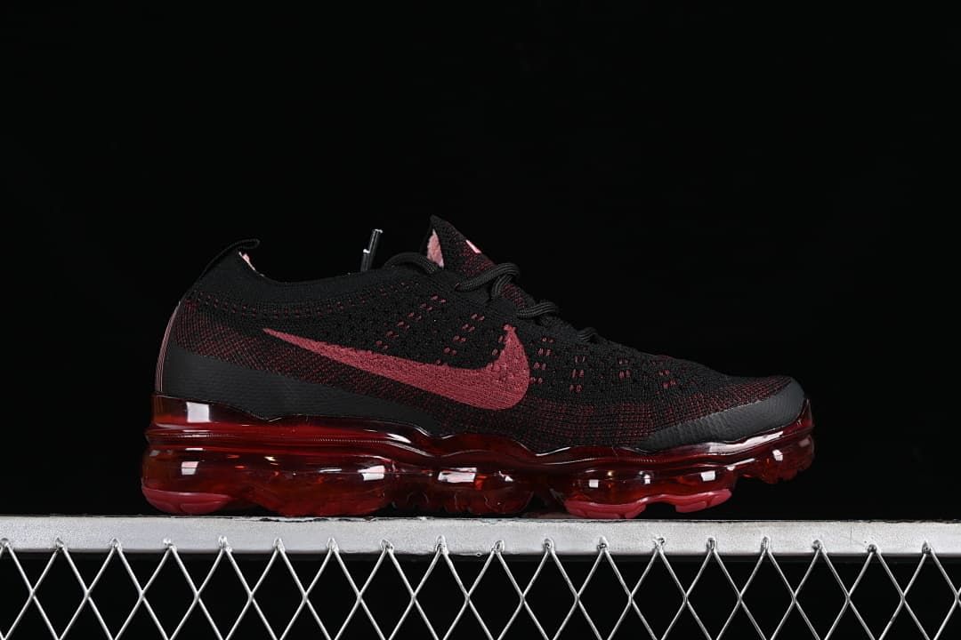 Side profile of the black and dark red sneaker with translucent red sole