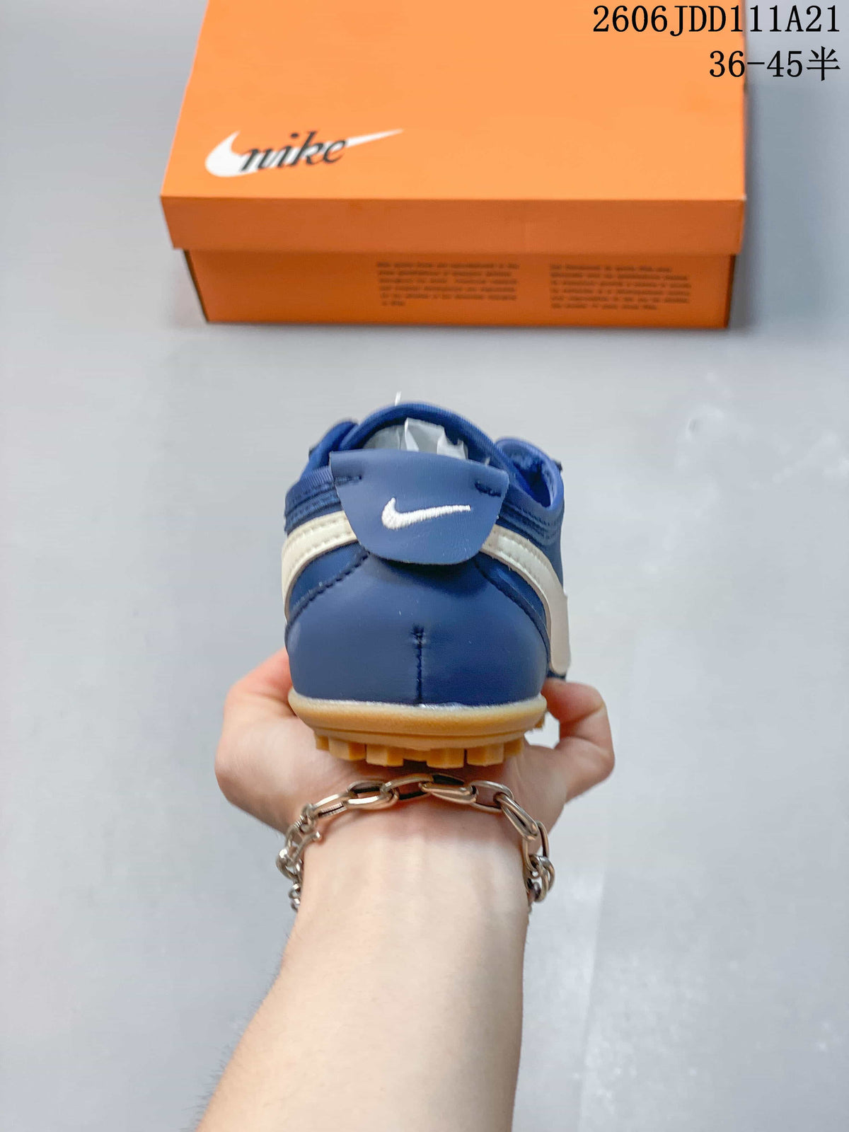 Rear view of the blue sneaker with white side detailing and gum-colored tread