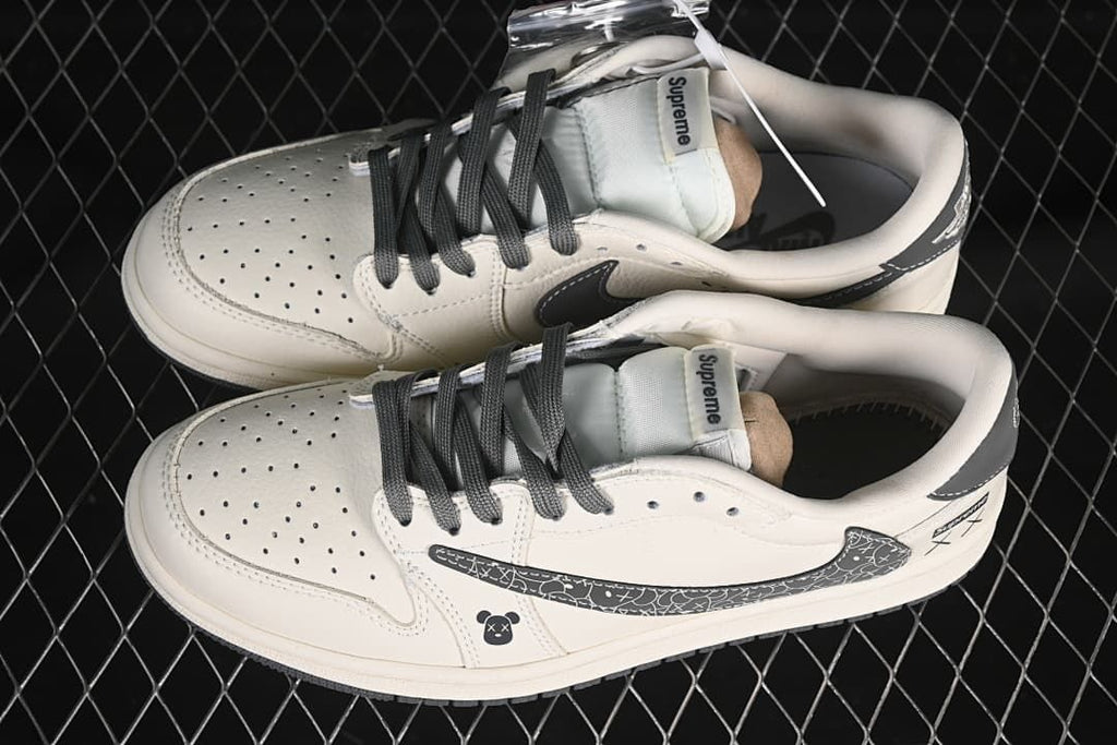 Overhead view of a pair of off-white low-top sneakers with dark laces, perforated toe boxes, and patterned side panels.
