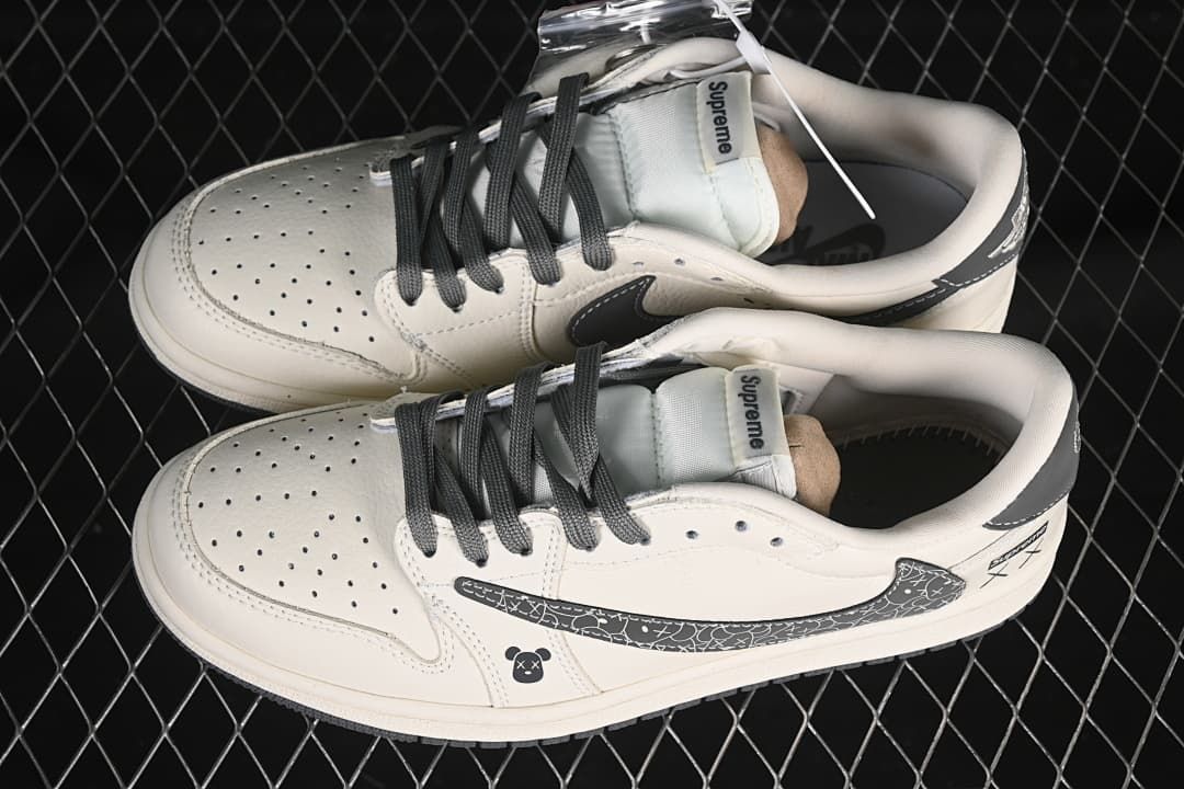 Overhead view of a pair of off-white low-top sneakers with dark laces, perforated toe boxes, and patterned side panels.