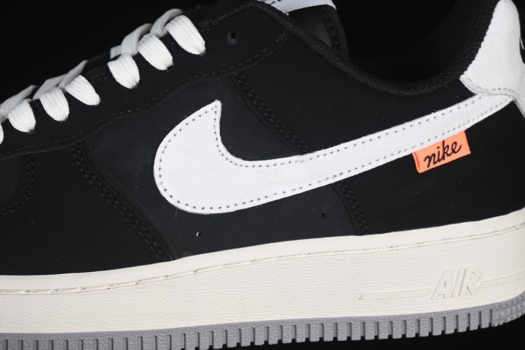 Close-up of white Swoosh, orange side tab, and off-white midsole