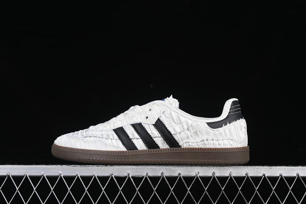 Side profile showing the textured white upper, black stripes, and dark brown sole