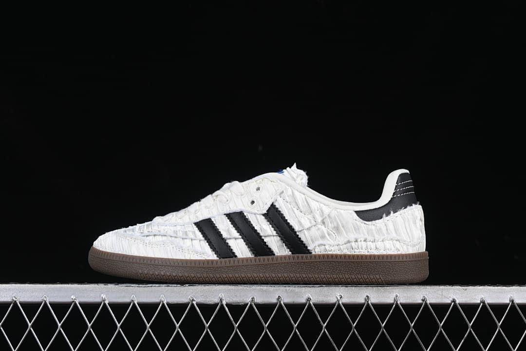 Side profile showing the textured white upper, black stripes, and dark brown sole