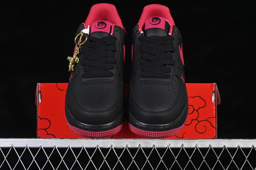 Pair of black low-top sneakers with red accents and red outsoles, shown from the front