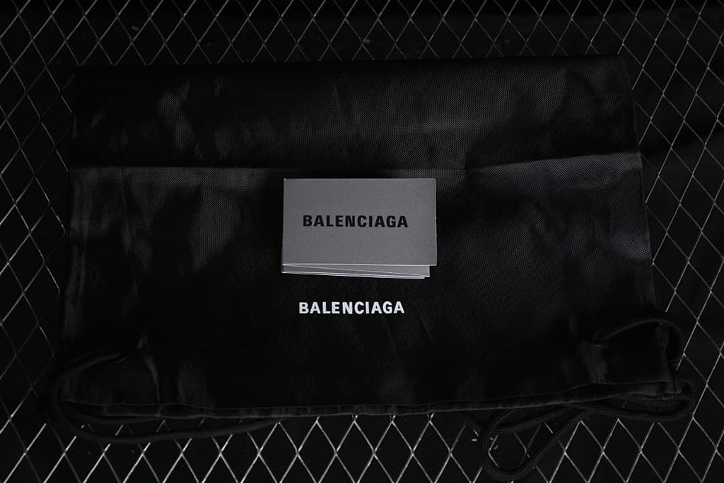 Black branded dust bag and card shown with the sneakers