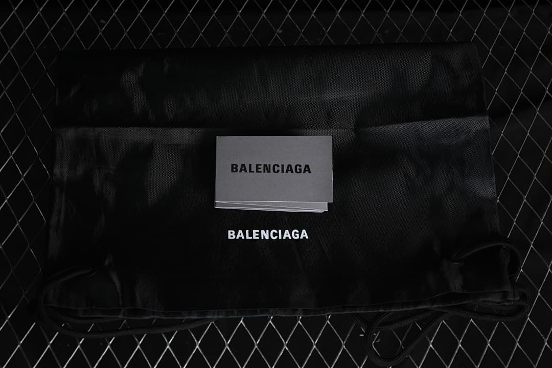 Black branded dust bag and card shown with the sneakers