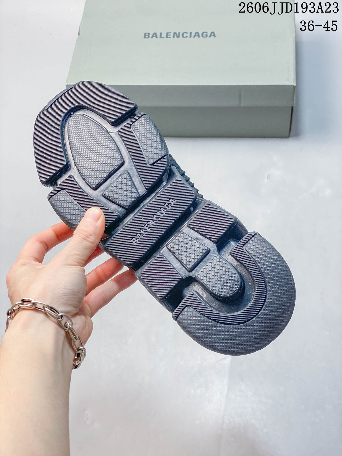 Underside of a navy sneaker showing a textured segmented sole