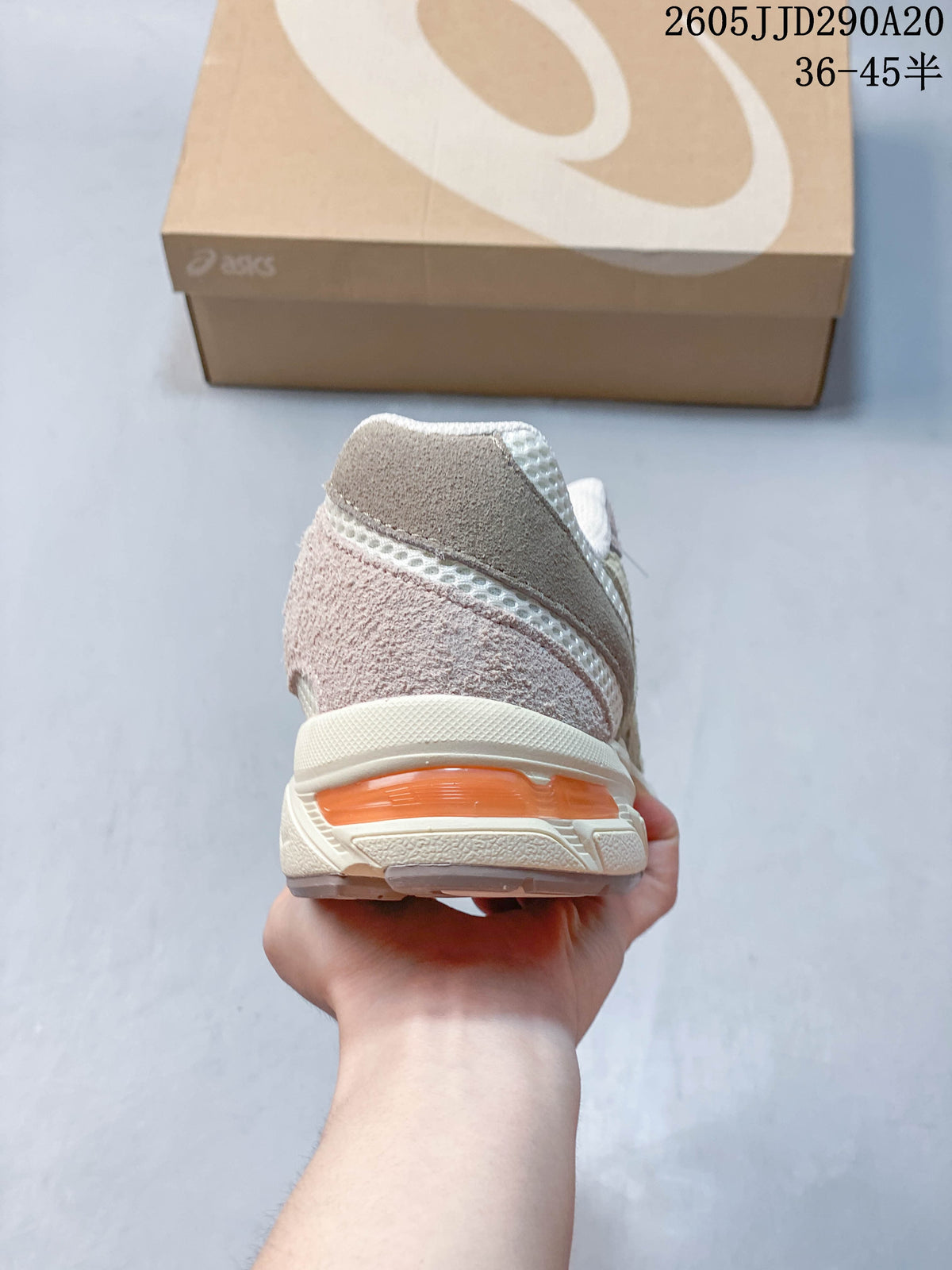 Rear view of the sneaker showing layered heel panels and an orange-toned midsole detail.