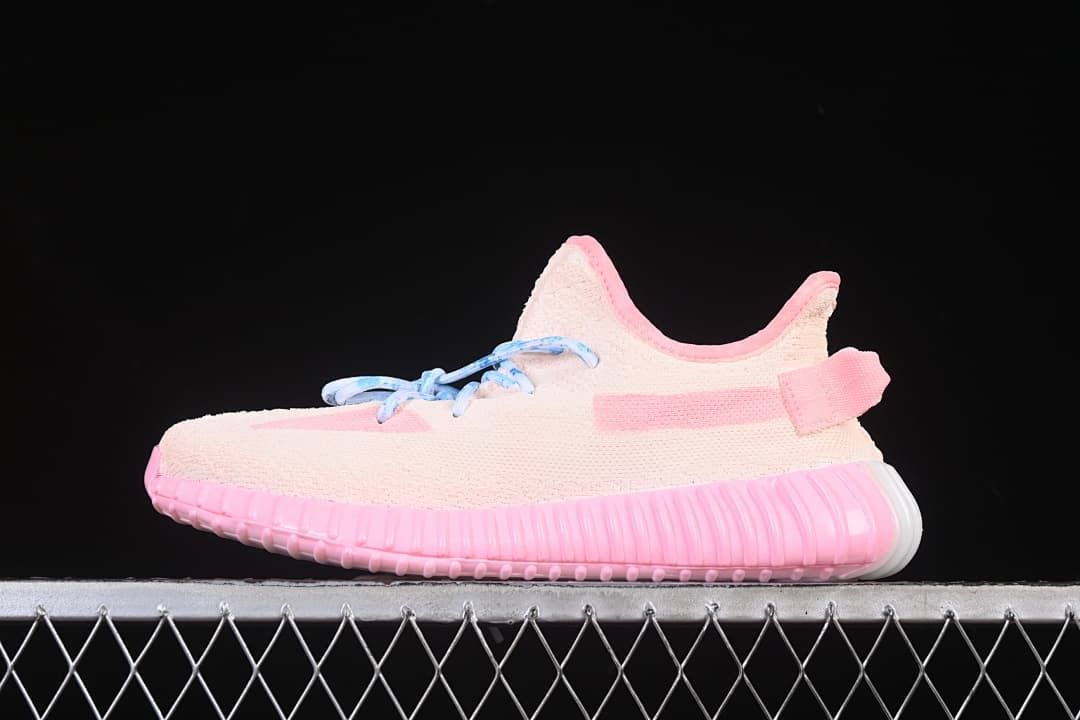 Side view of a pale pink Yeezy 350 Boost V2 sneaker with blue laces and a ribbed pink sole.