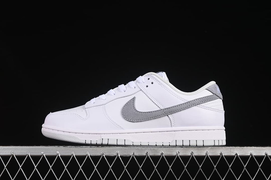 Side profile of a white and grey Nike SB Dunk Low sneaker