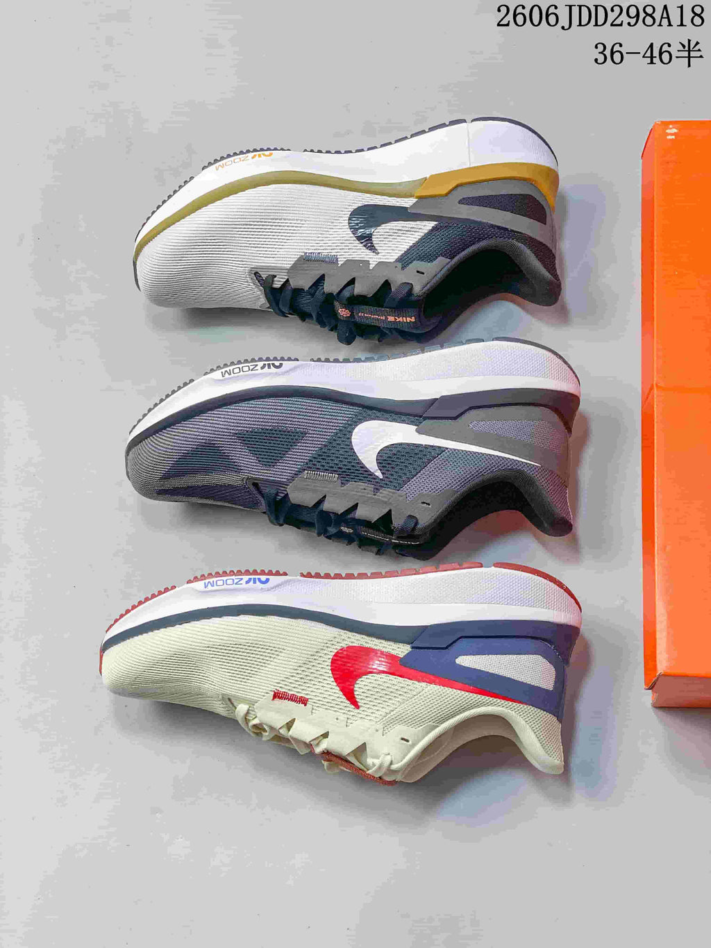 Three Nike running shoes shown from the side in grey, white, and red-accented colorways