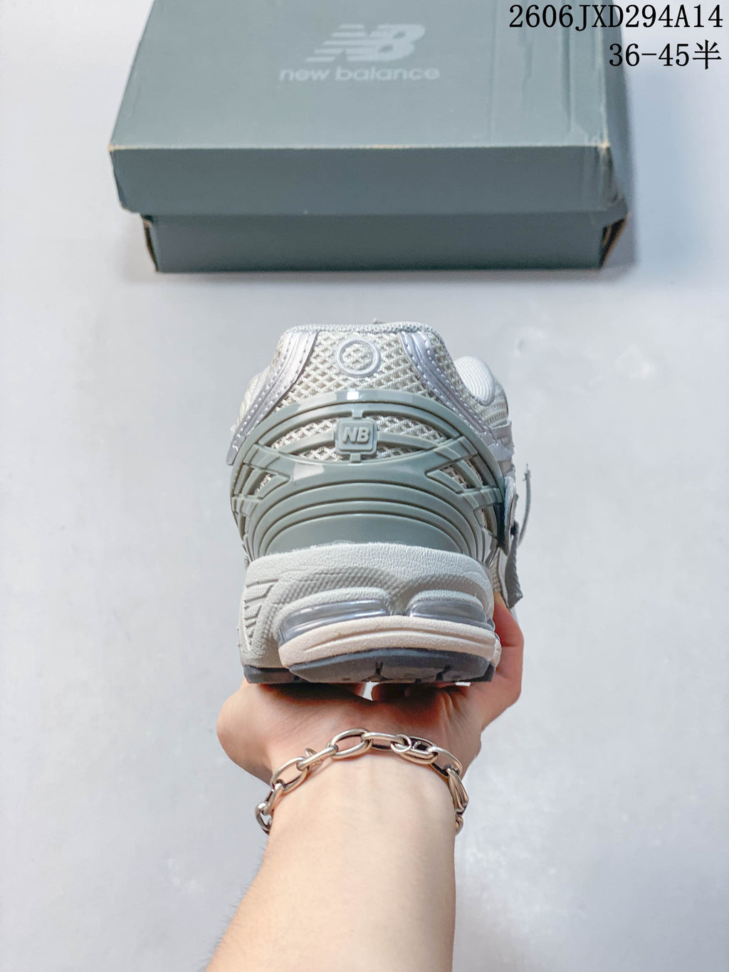 Heel view of a silver-grey New Balance 1906 sneaker.