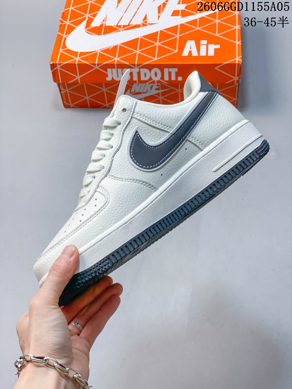 Side view of the white low-top sneaker with grey side detailing and a dark outsole.