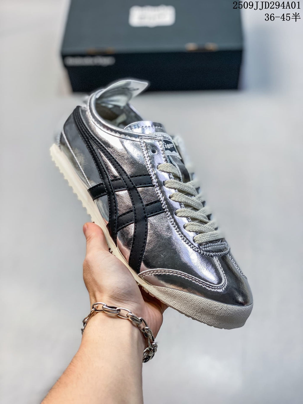 Angled side view showing the reflective silver upper, dark stripes, and low-profile sole.