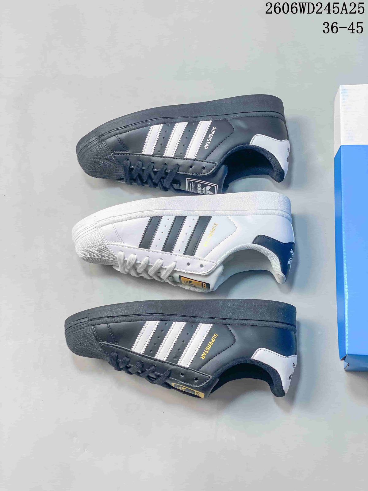 White and charcoal Superstar sneakers shown from the side