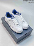 Pair of white Nike Air Force 1 Low sneakers with blue collars and outsoles, displayed on a shoe box.
