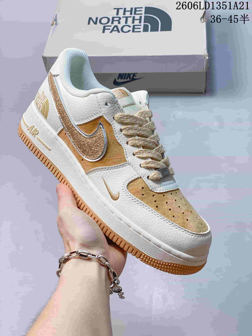 White low-top sneaker with gold glitter Swoosh and warm tan accents