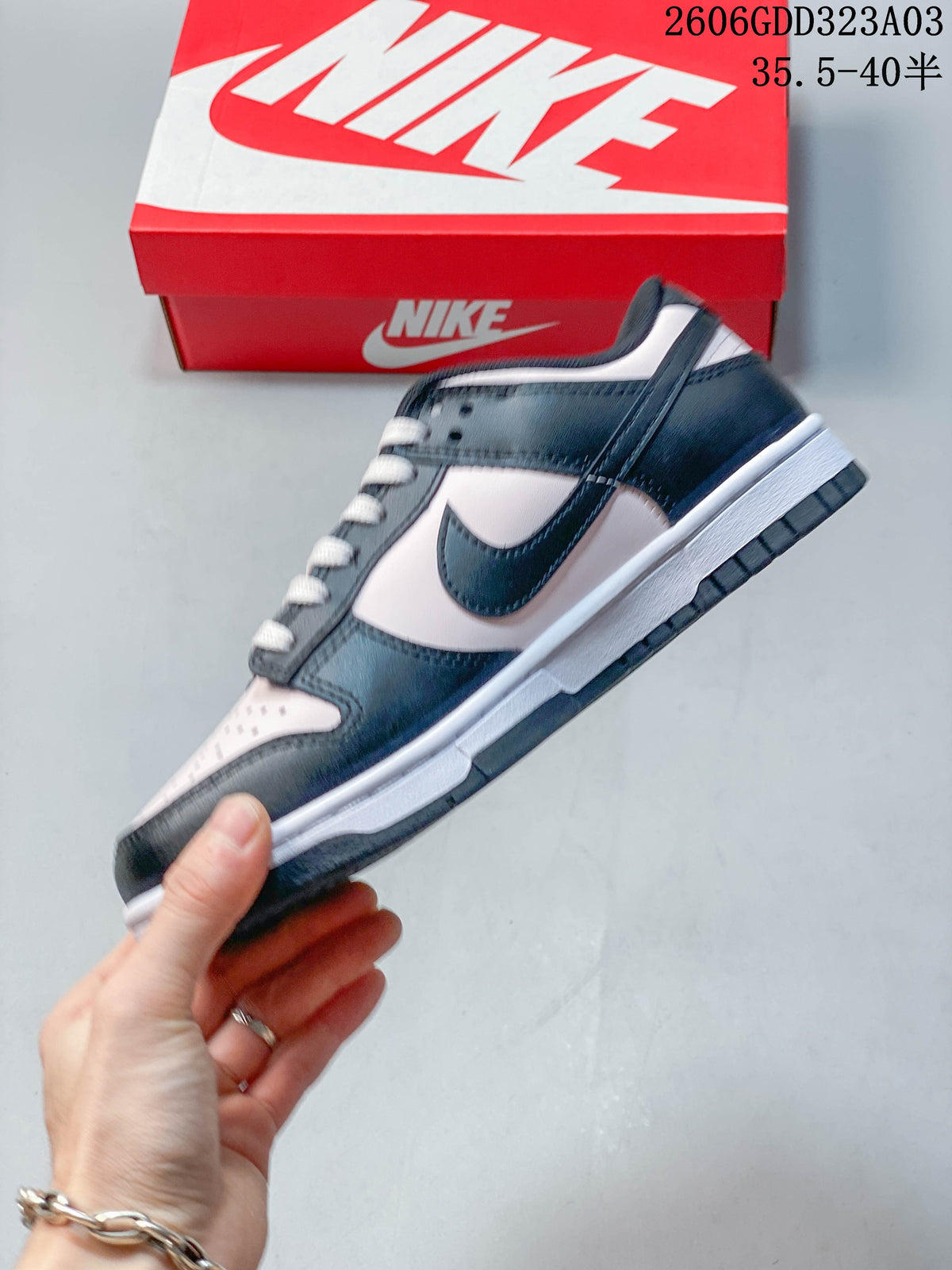 Side view of the black and pale pink low-top sneaker