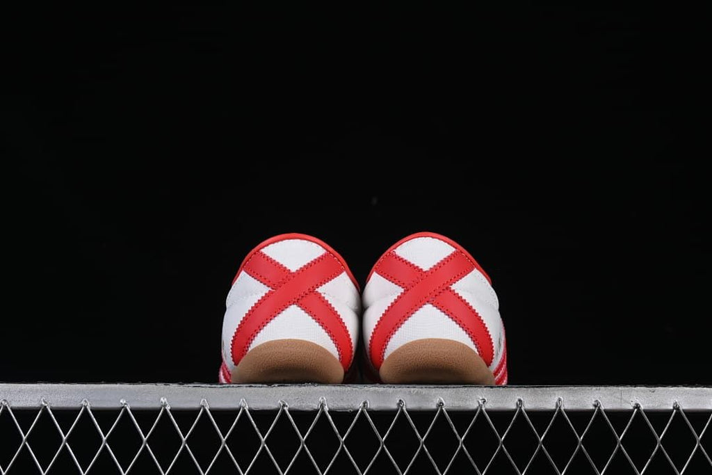 Rear view of both sneakers showing red crossed heel overlays
