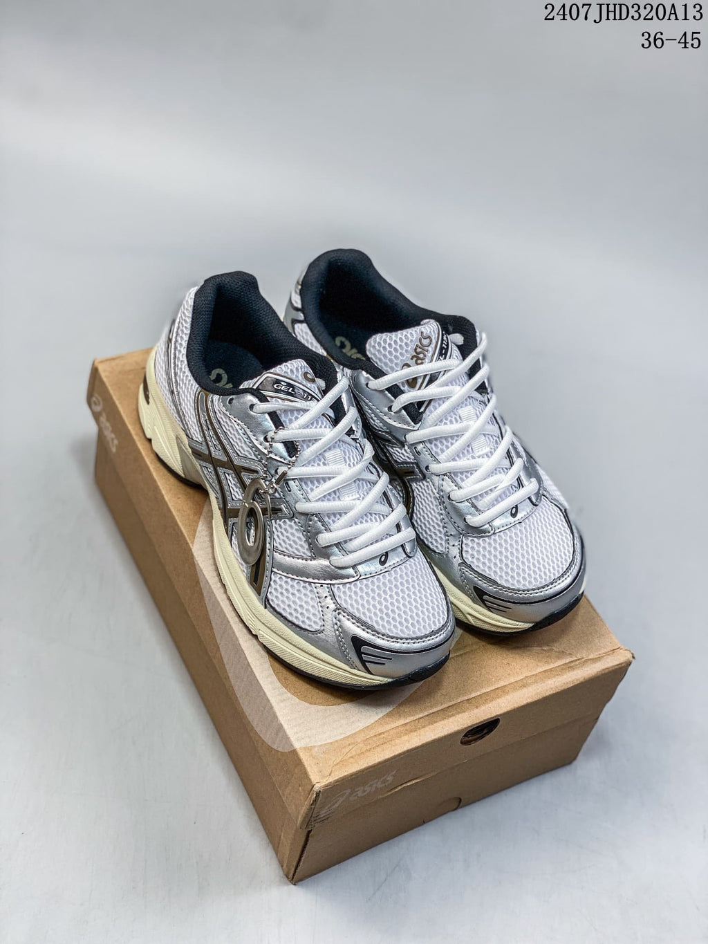 Pair of silver and white ASICS GEL-1130 sneakers displayed on a shoebox