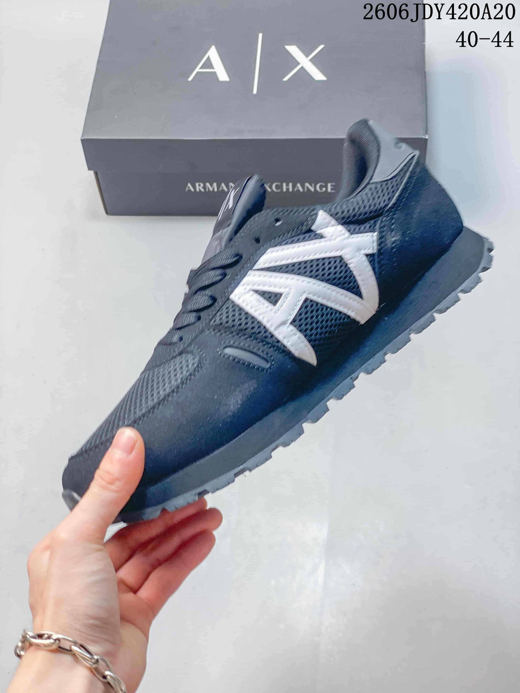 Side view of a navy mesh sneaker with white Armani Exchange logo detailing