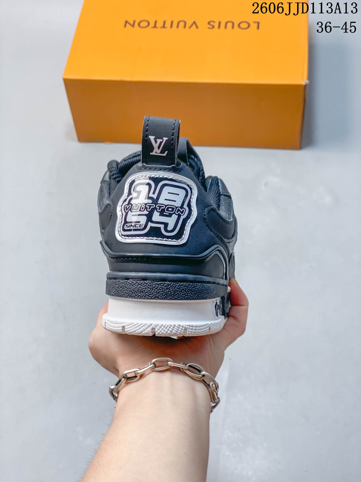 Rear view of the dark navy sneaker with a branded heel panel and white outsole.