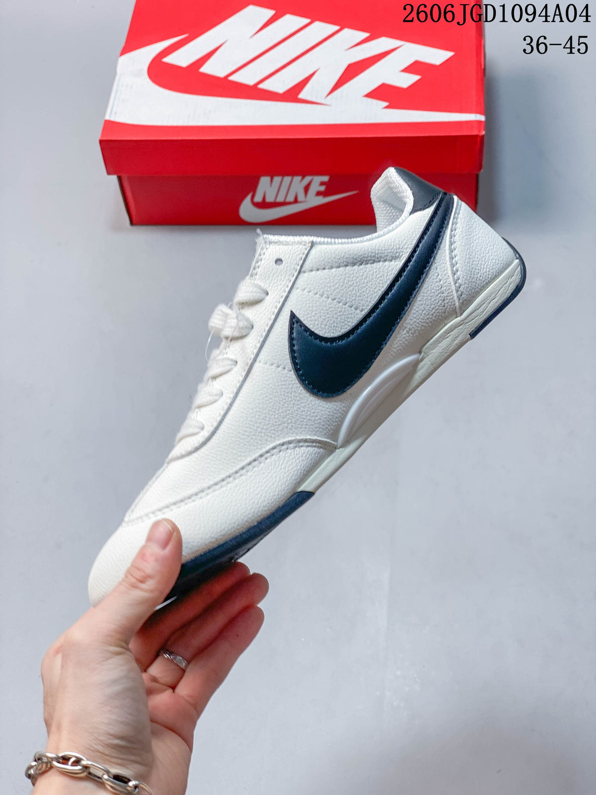 Side view of a white low-top sneaker with a dark Swoosh and contrast outsole accents