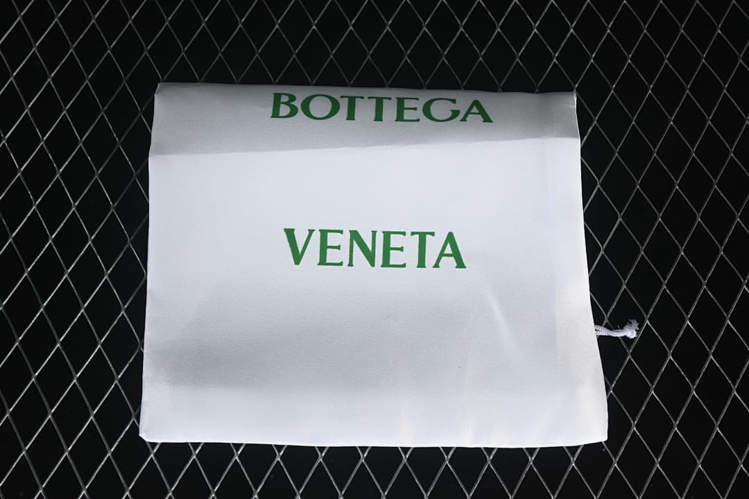 White drawstring dust bag with green Bottega Veneta lettering.