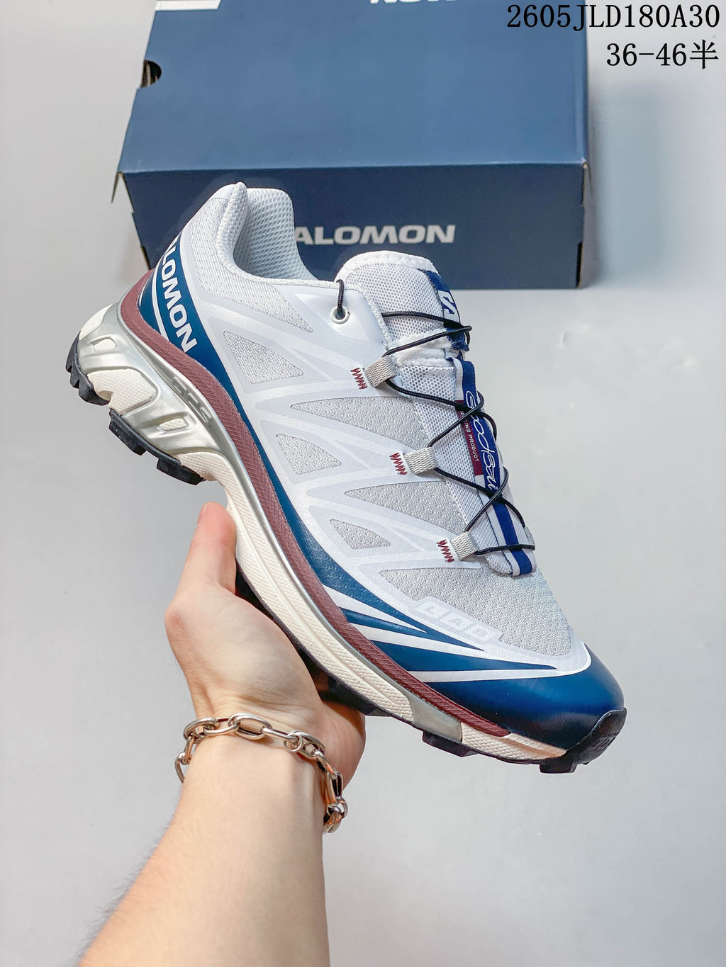 Angled side view of the white and blue Salomon XT-6 shoe
