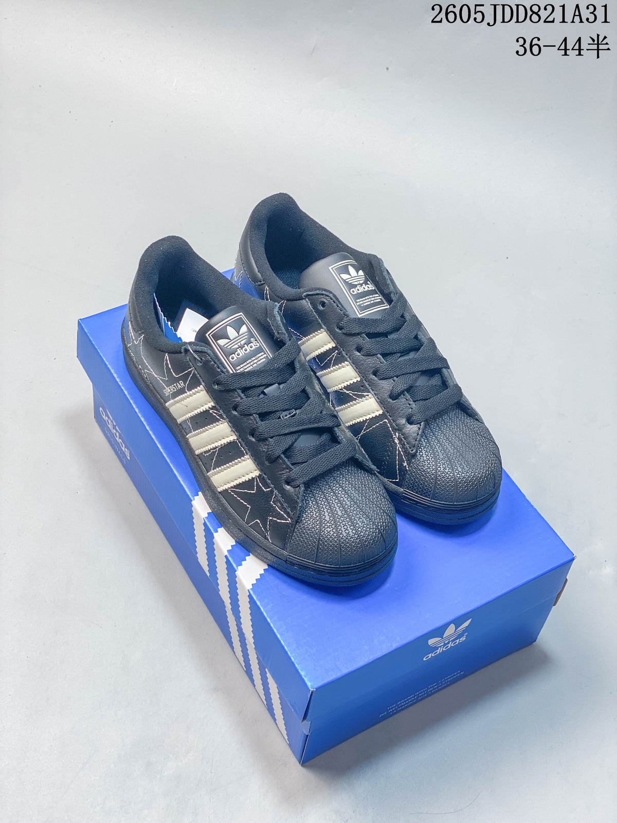Pair of dark Adidas Superstar sneakers with light stripes and star-patterned side panels.