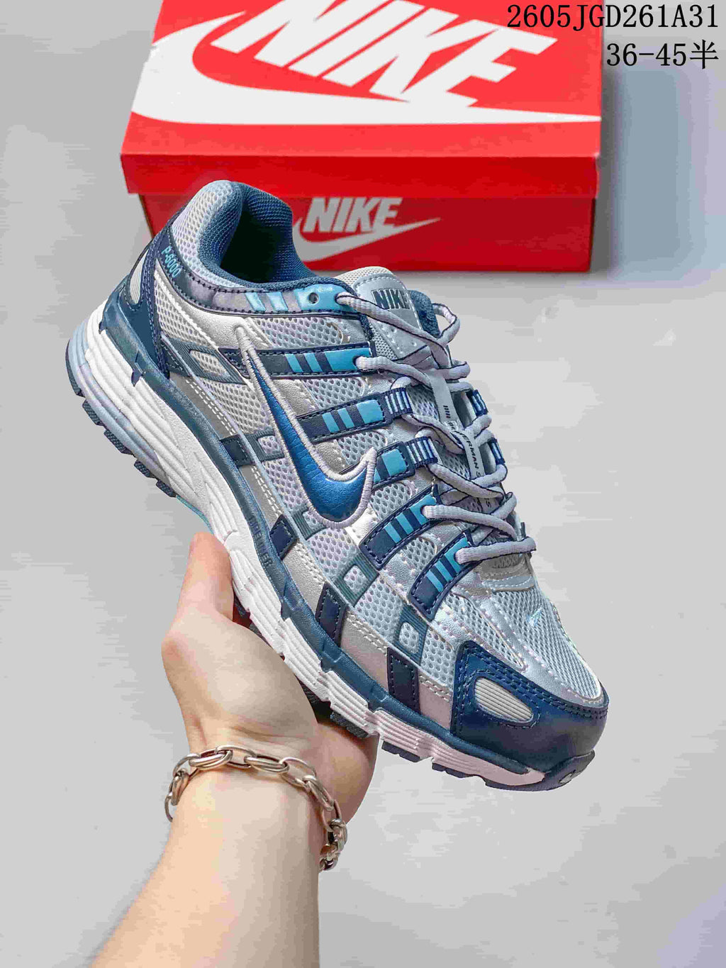Side view of a gray and white Nike P-6000 sneaker with blue accents.