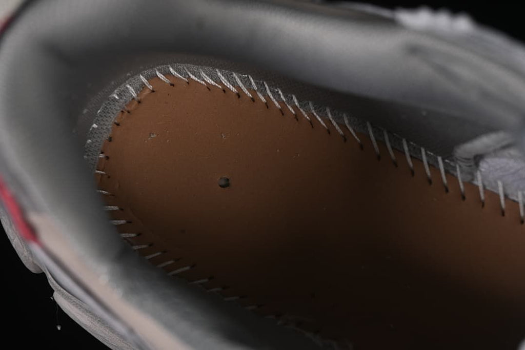 View inside the sneaker showing the footbed and stitched edge.
