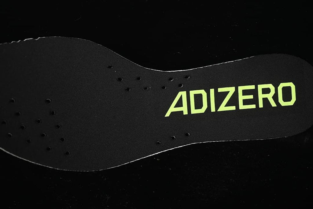Black Adizero shoe insert with lime lettering
