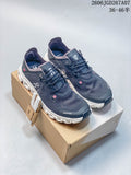 Pair of dark navy On Cloud 6 Coast low-top shoes with white segmented soles and pink accents, shown on a shoe box.