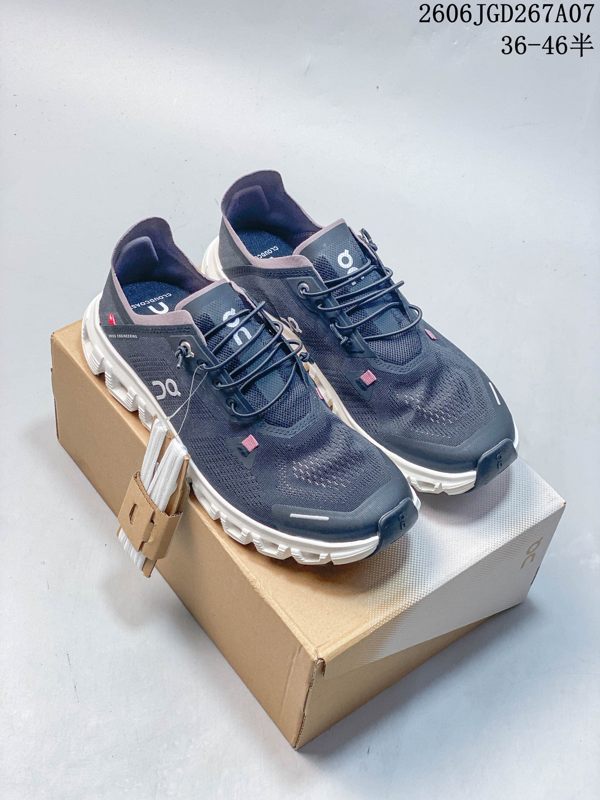 Pair of dark navy On Cloud 6 Coast low-top shoes with white segmented soles and pink accents, shown on a shoe box.