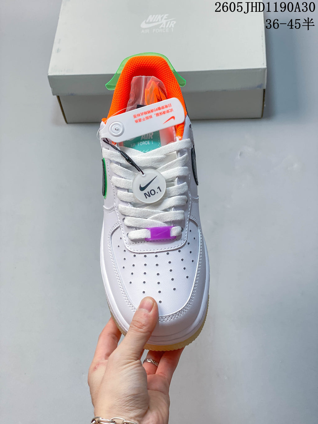 Front view showing perforated toe, white laces, orange lining, and purple lace accent