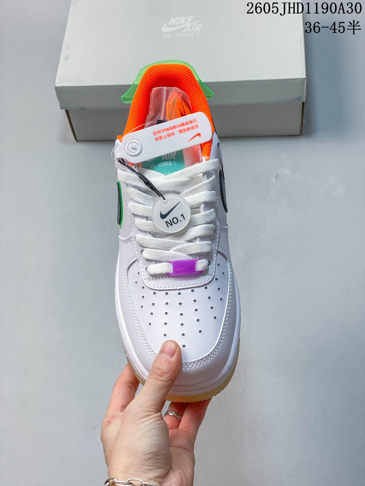 Front view showing perforated toe, white laces, orange lining, and purple lace accent