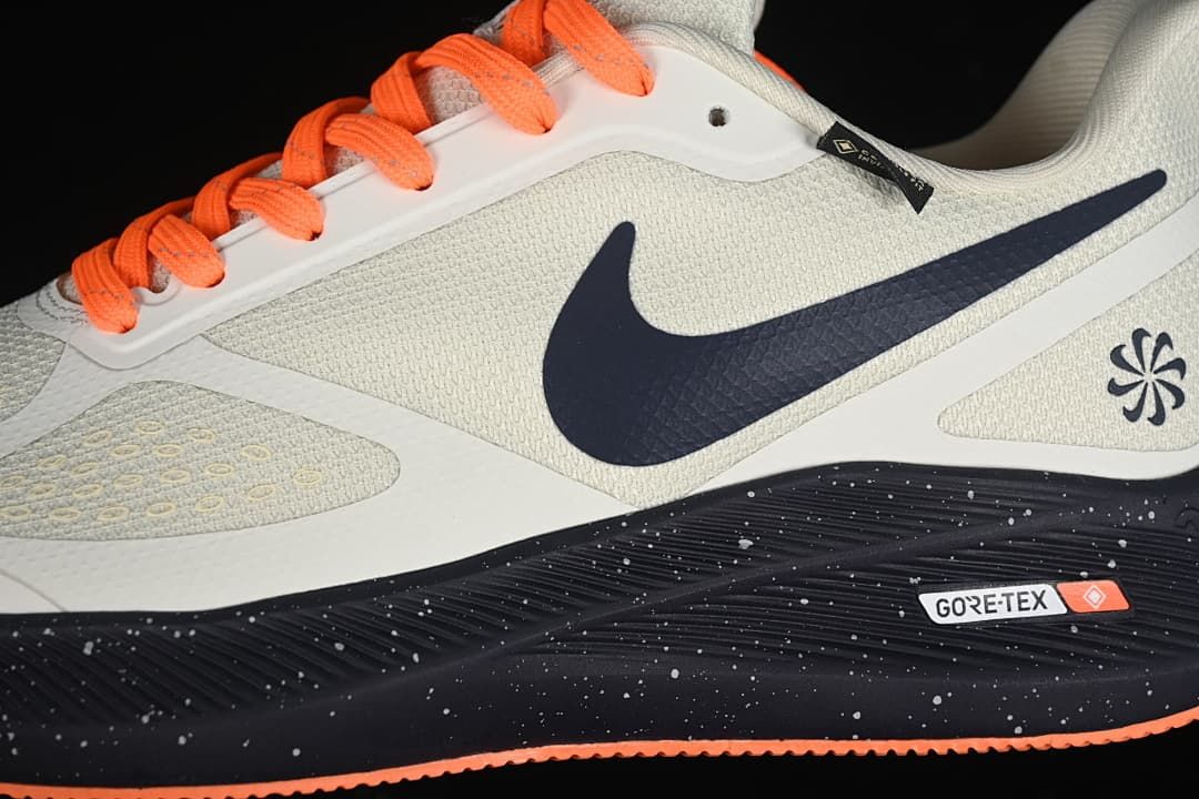 Close-up of the shoe side with navy swoosh, bright orange laces, and GORE-TEX badge