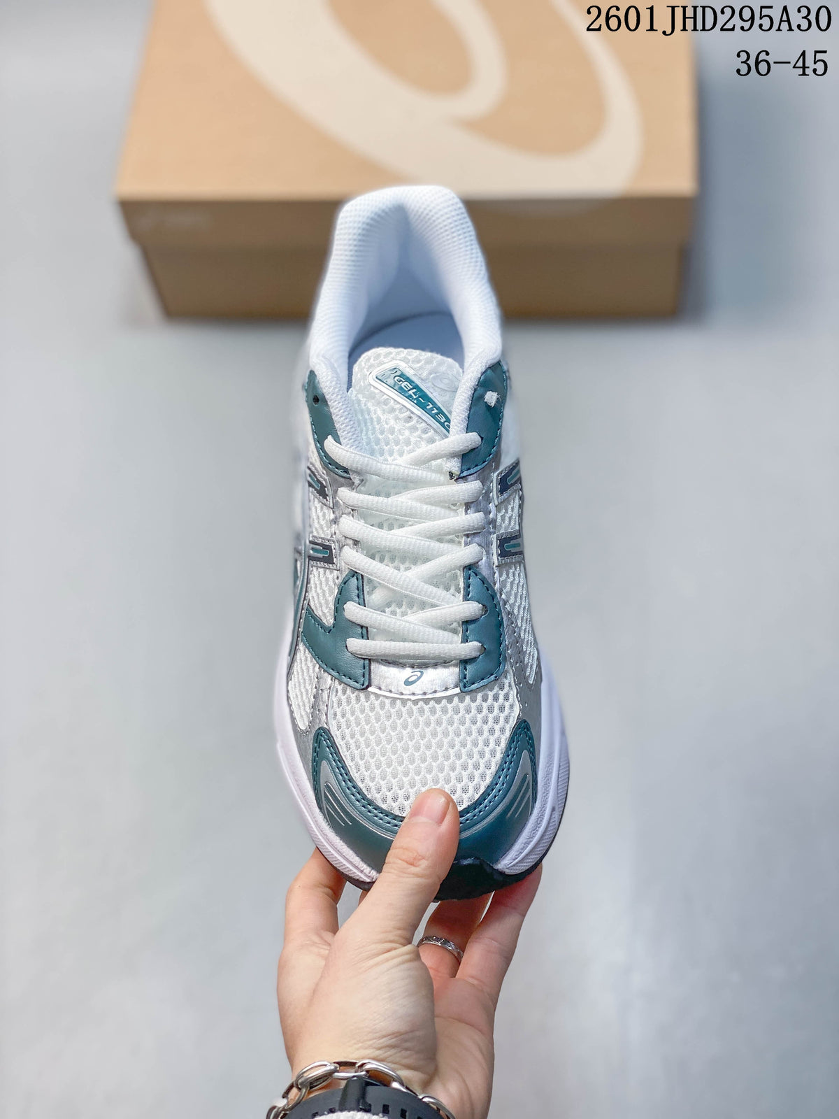 Front view showing the laces, mesh-look upper, and teal toe accents
