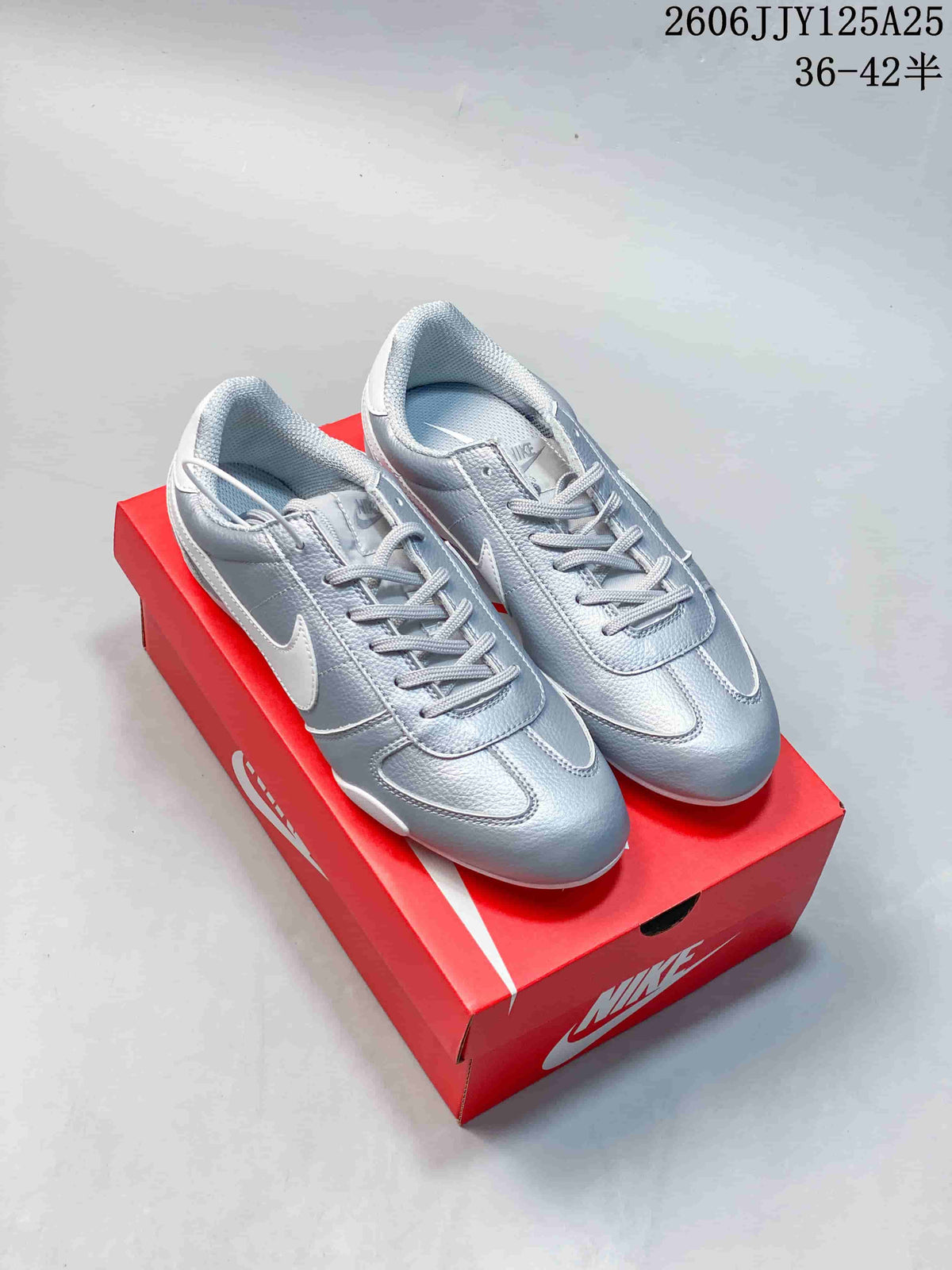 Pair of metallic silver low-profile Nike Sprint Sister sneakers on a red shoe box