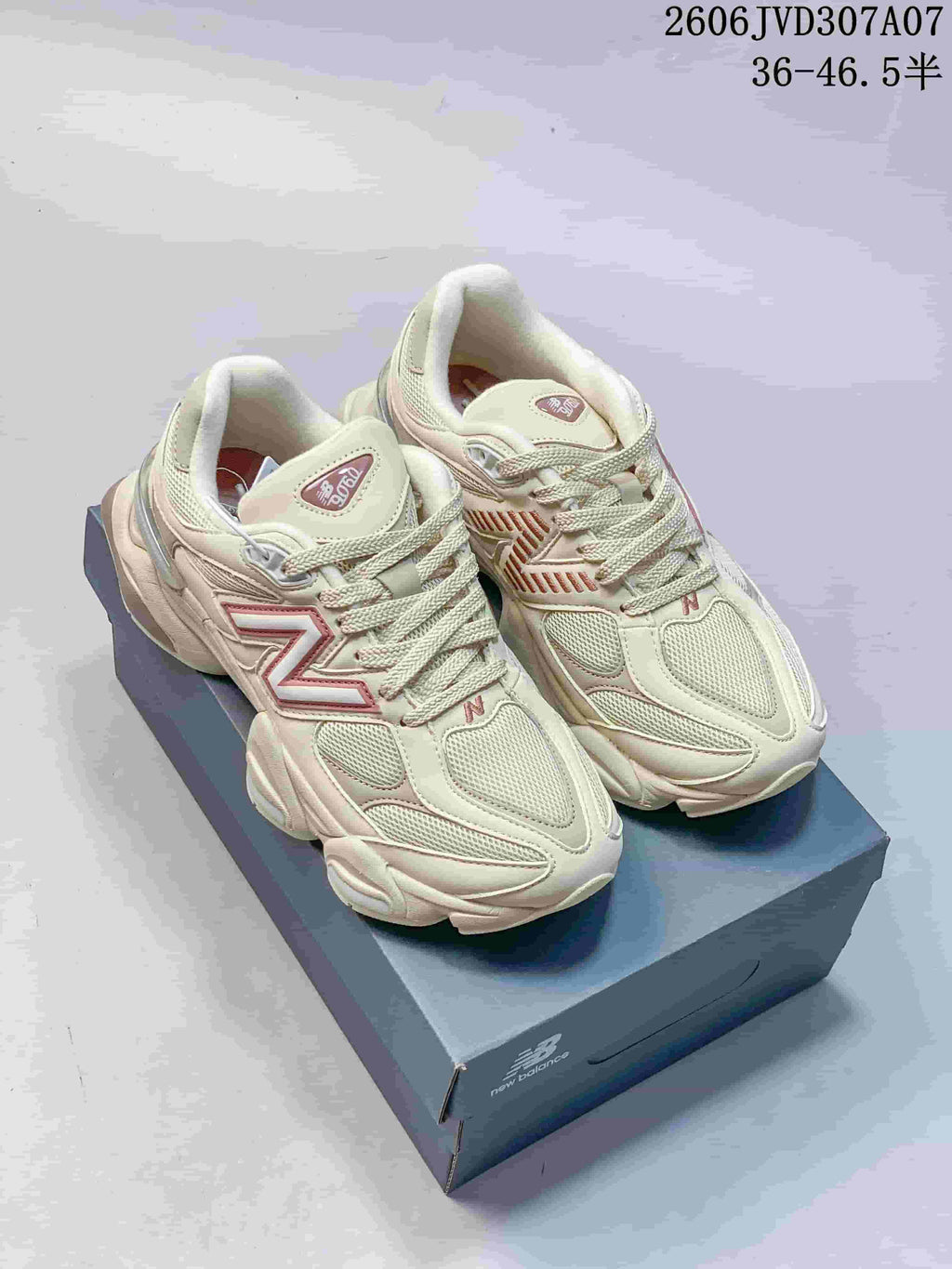 Pair of cream and pink New Balance 9060 sneakers shown from above on a shoebox; image overlay lists sizes 36–46.5.