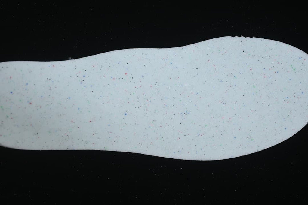 Light-colored sneaker insole with small colored speckles
